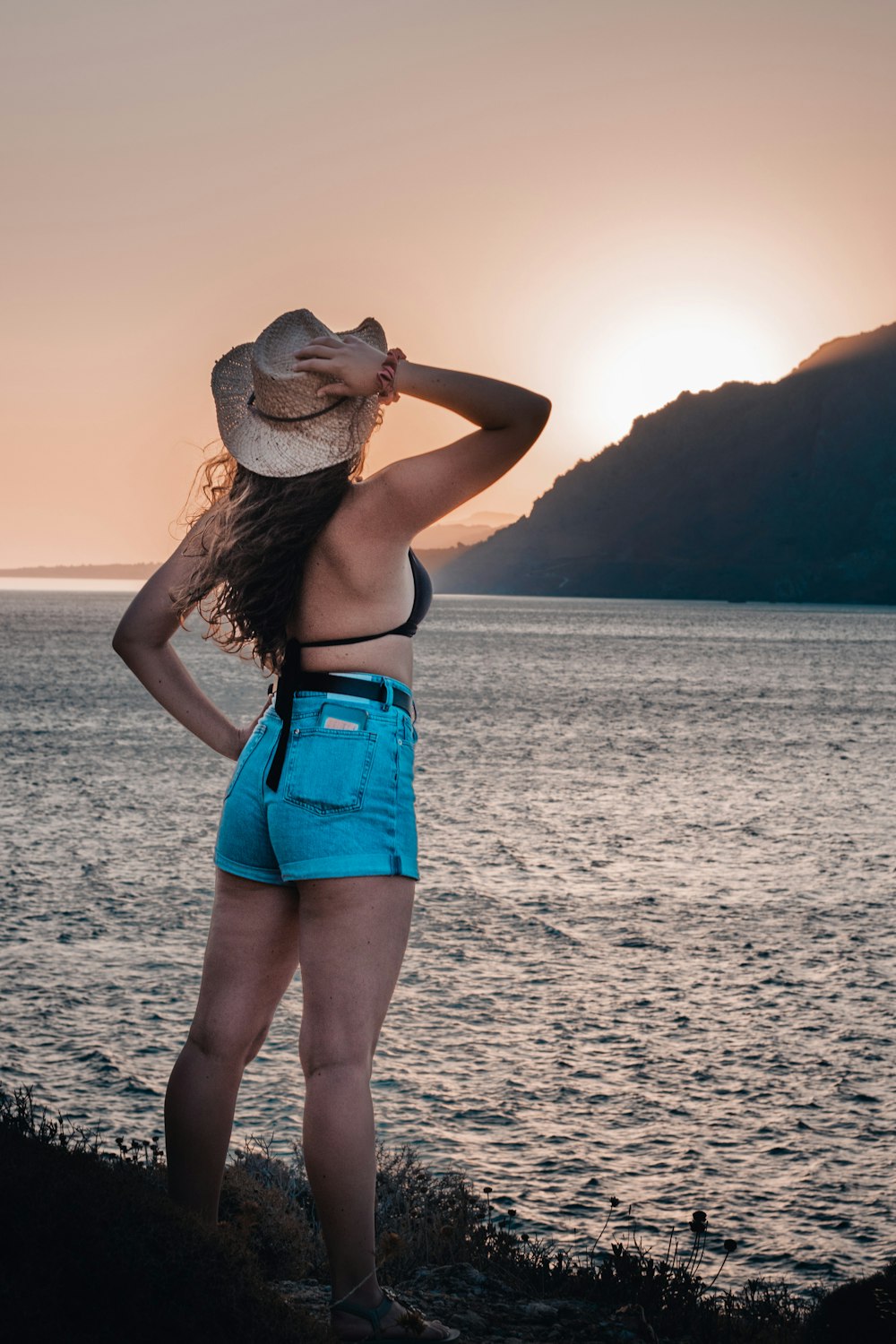 a woman standing on a cliff overlooking the ocean