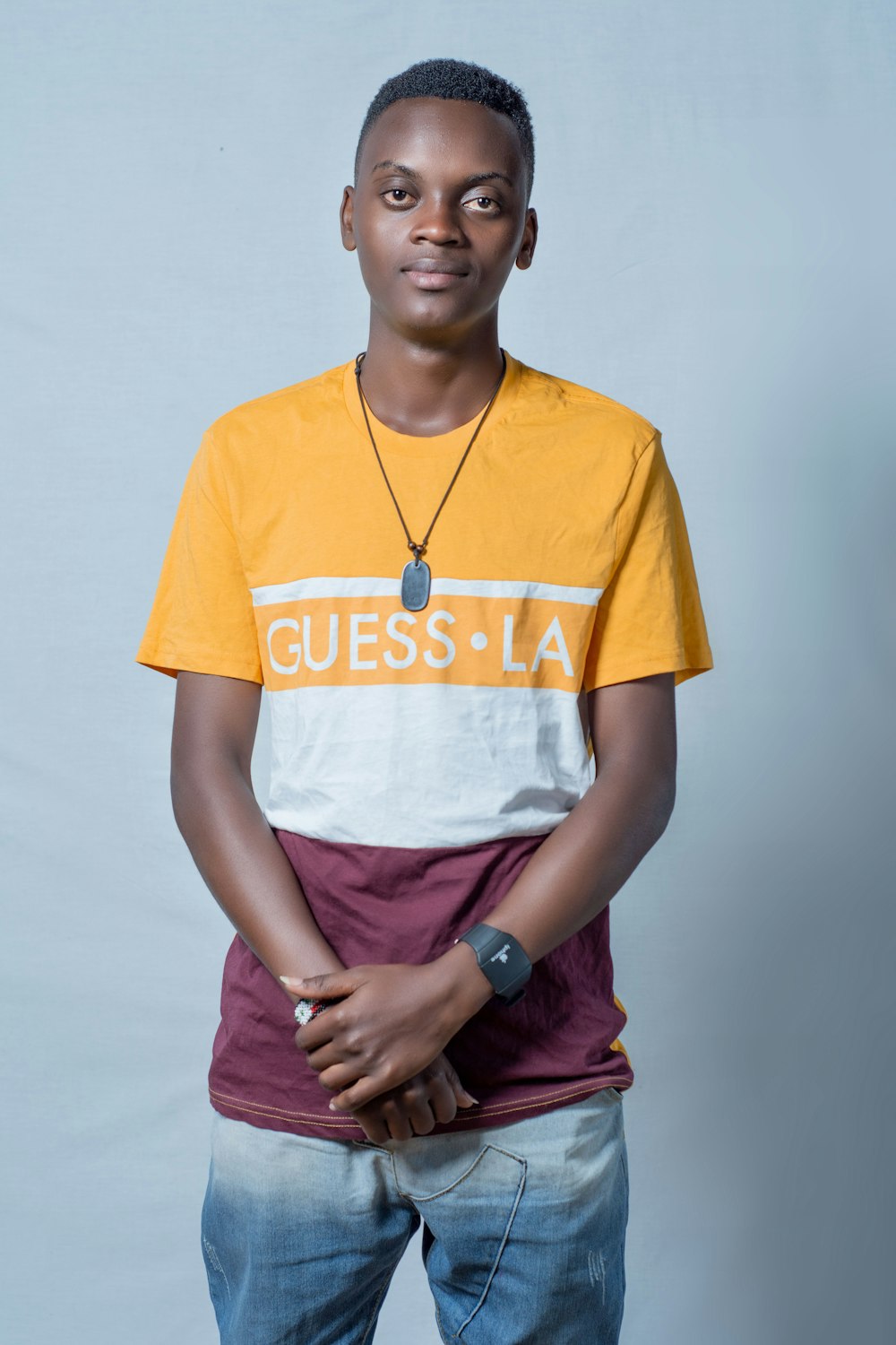 a young man wearing a yellow and white shirt