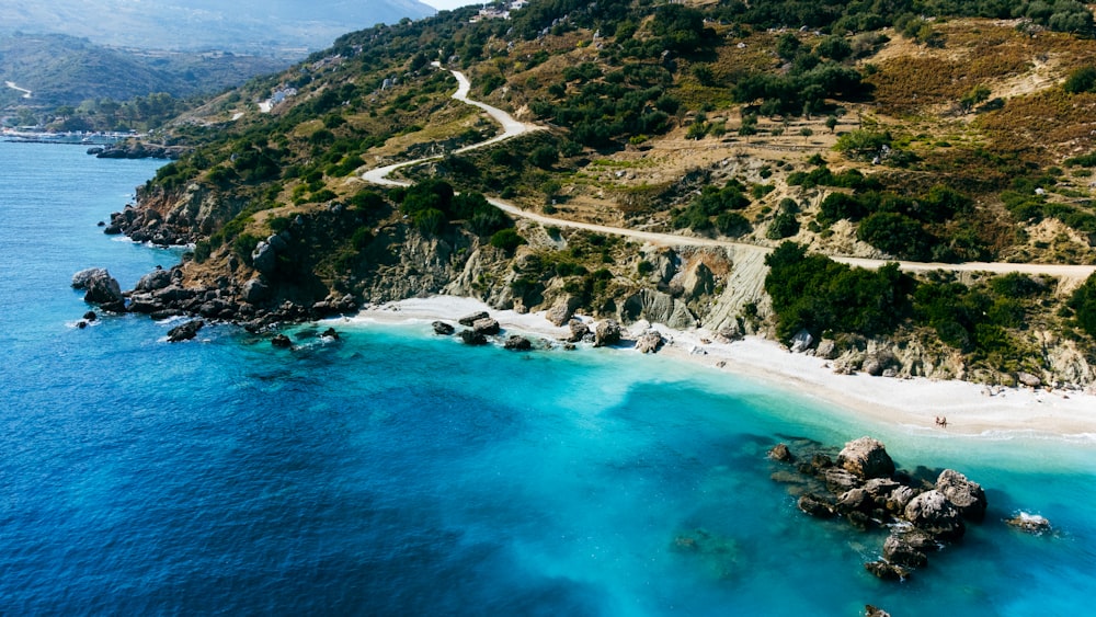 an aerial view of a sandy beach and blue water