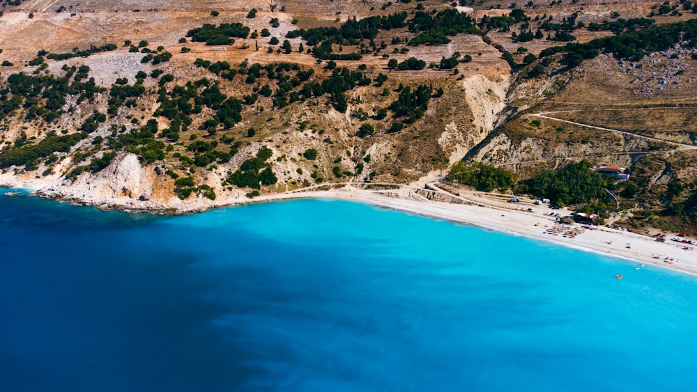 an aerial view of a beach with blue water