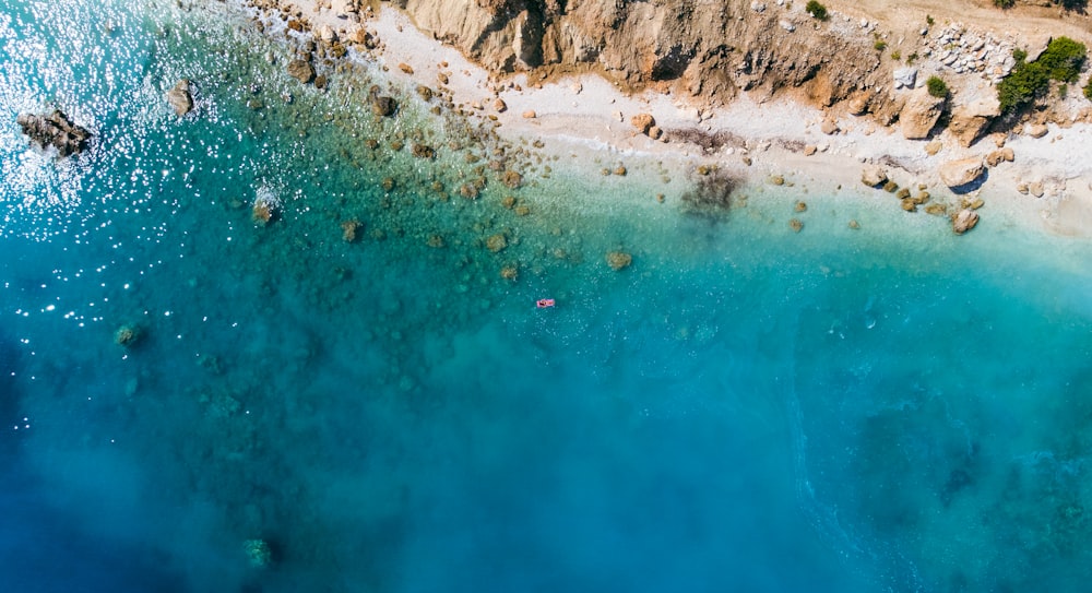 an aerial view of a sandy beach and blue water