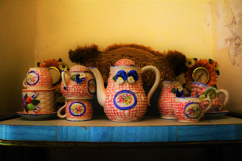 a blue table topped with lots of vases and dishes