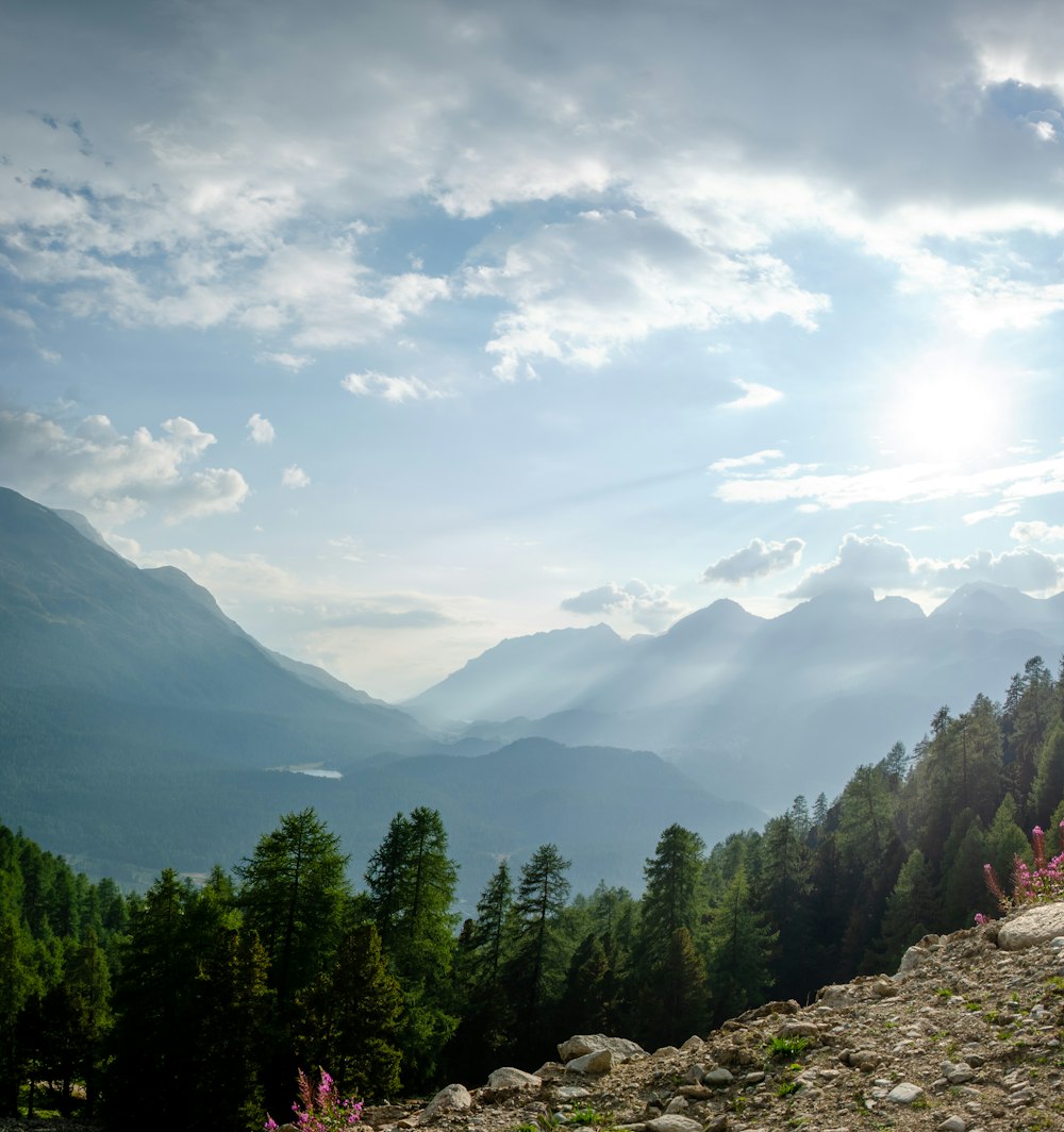 the sun shines through the clouds over the mountains