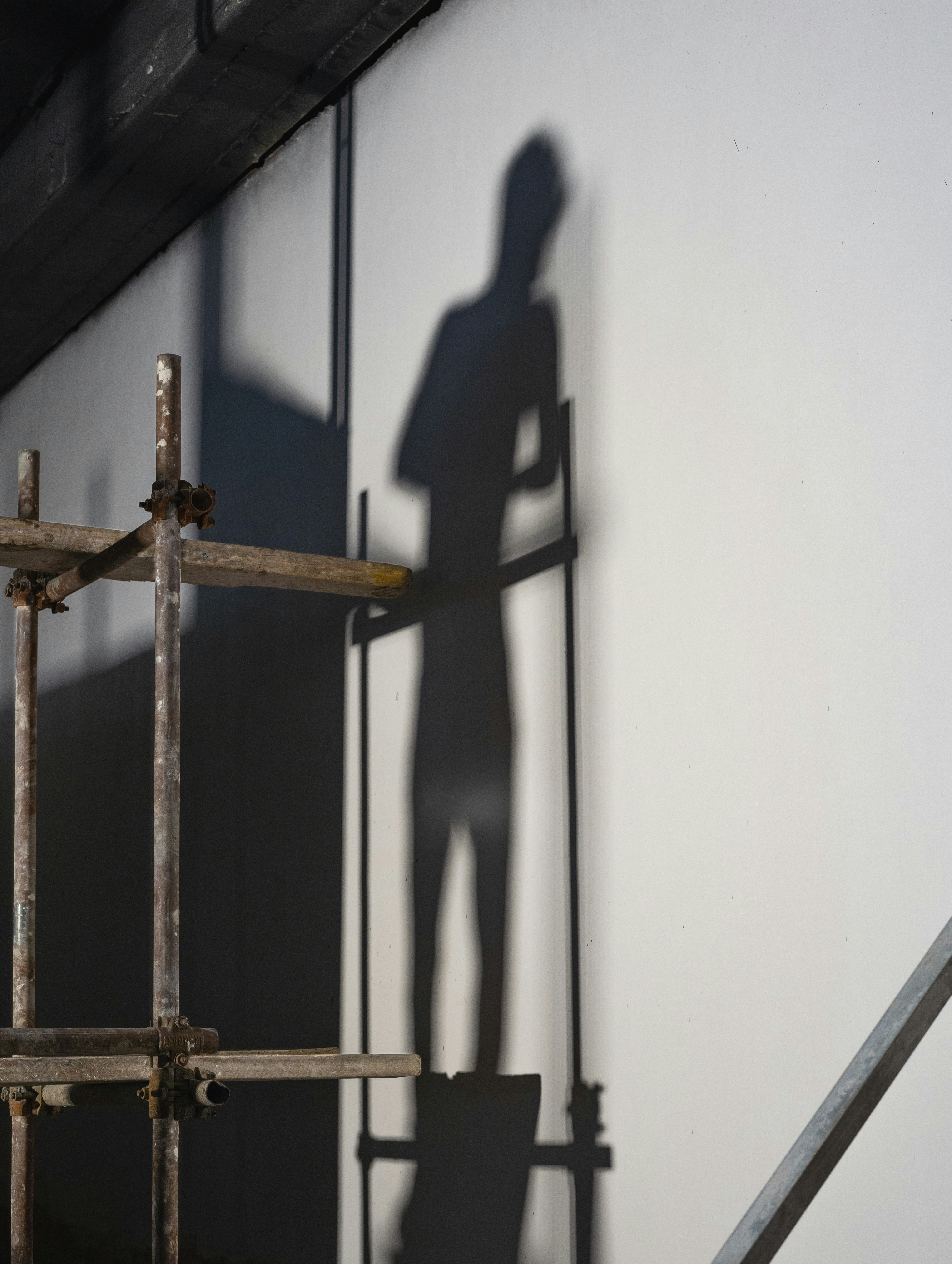 a shadow of a man standing on a ladder