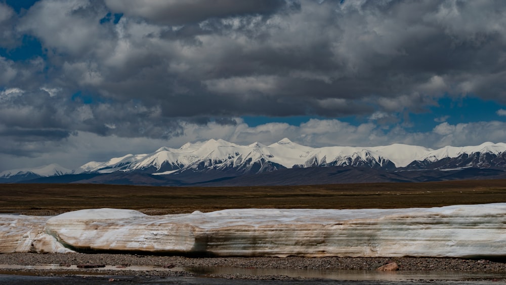 a large rock laying on top of a dry grass field