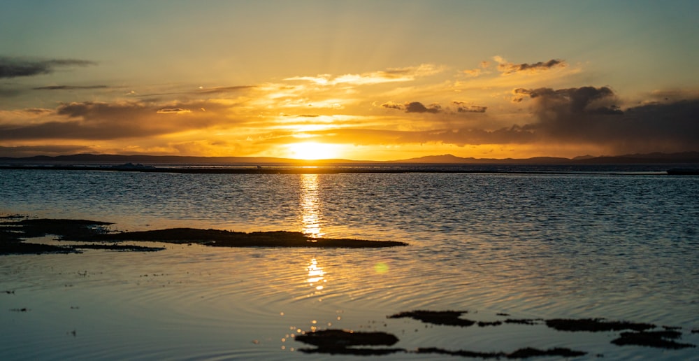 the sun is setting over a body of water