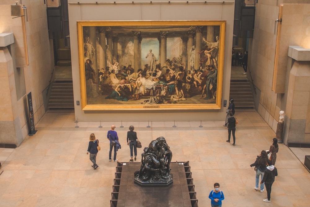 a group of people looking at a painting in a museum