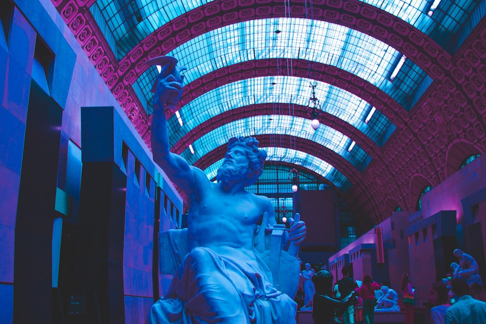 a statue of a woman holding a vase in a building