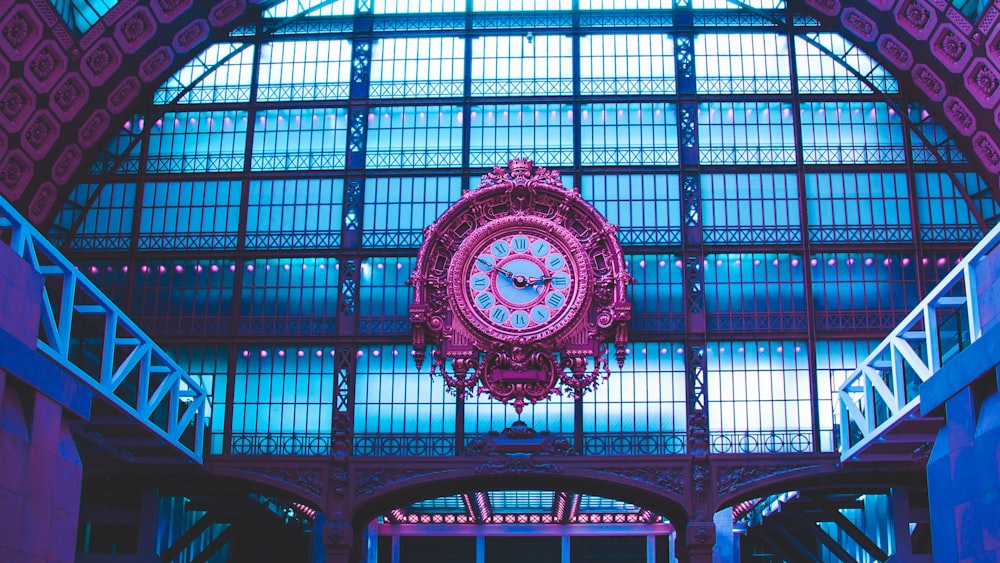 a large clock hanging from the ceiling of a train station