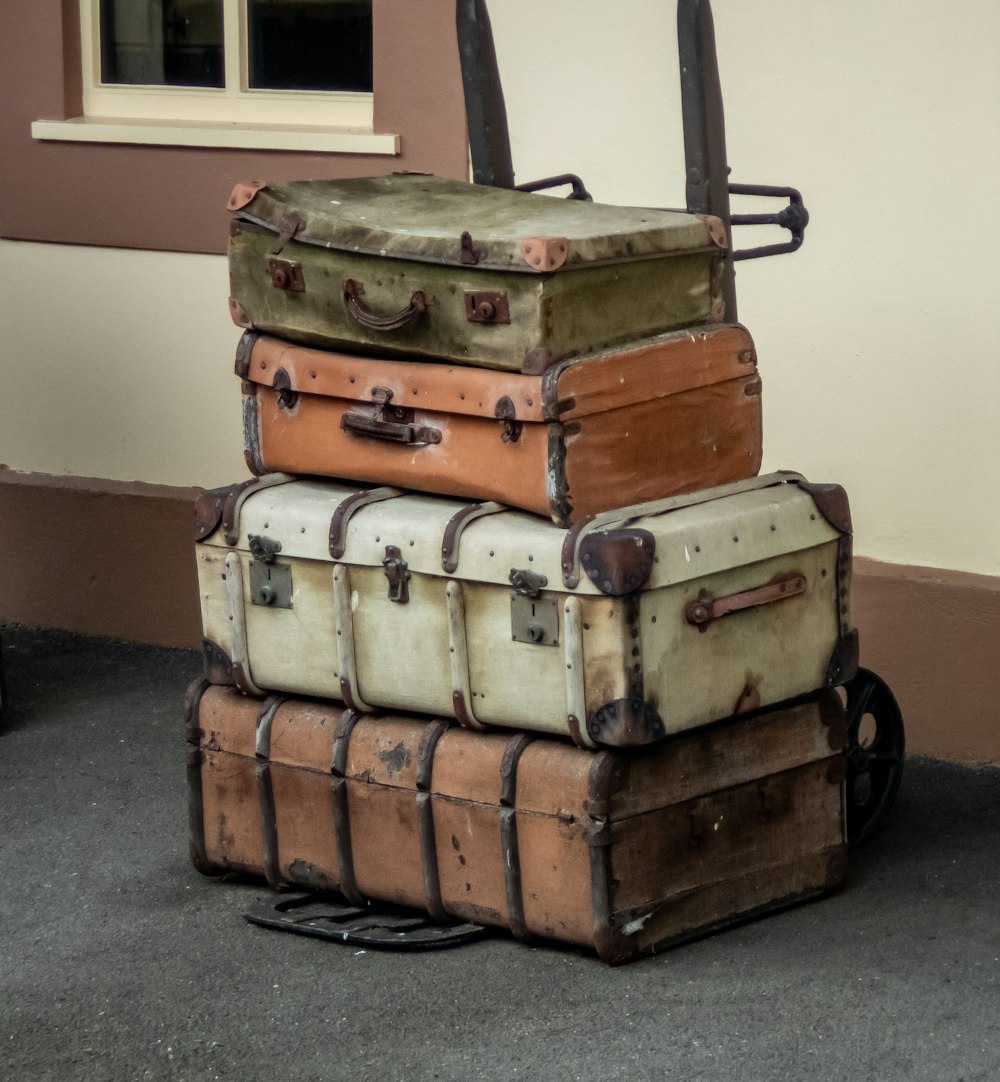 a stack of old suitcases sitting in front of a building