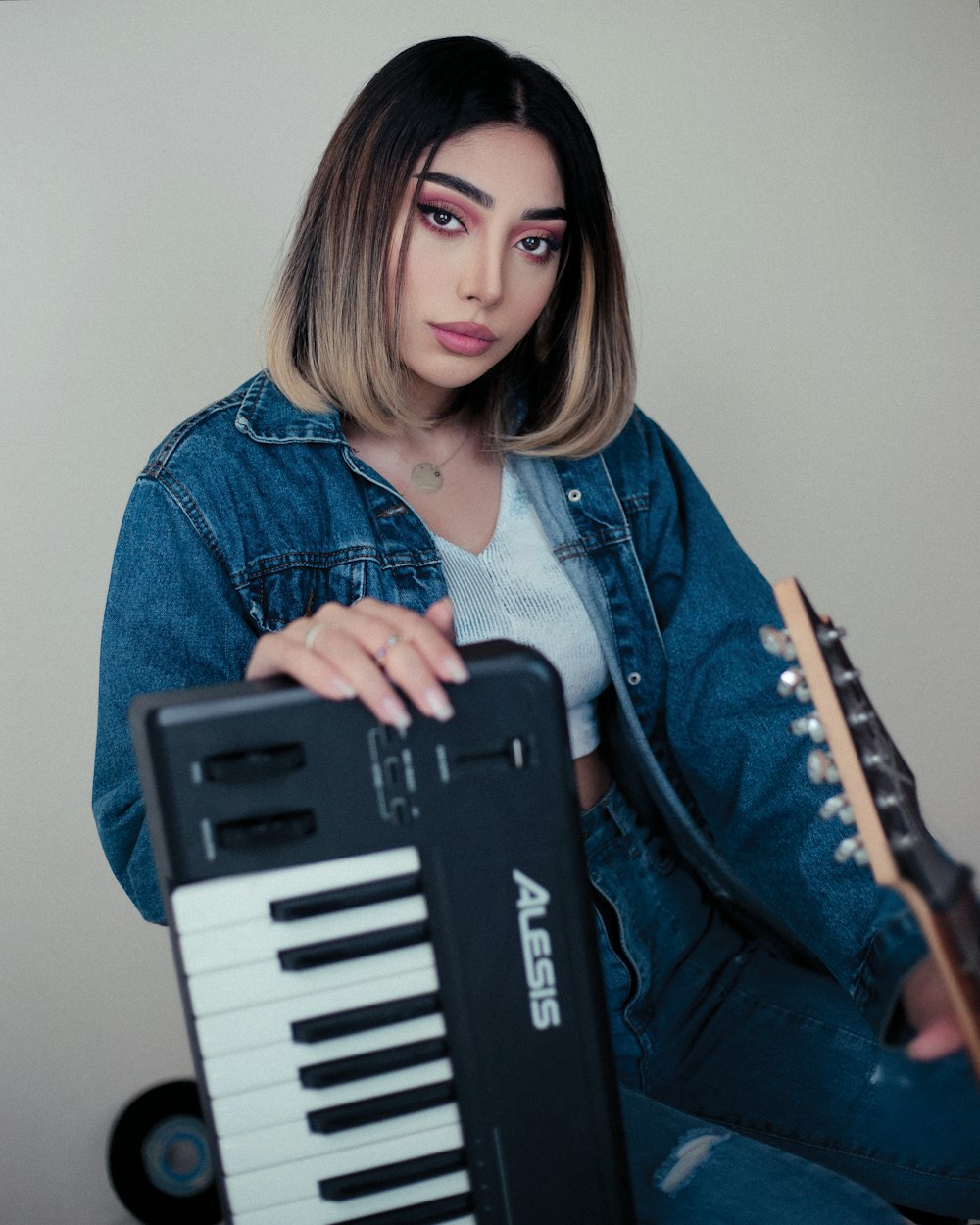 a woman sitting on the floor with a guitar