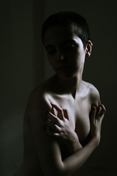 a naked woman with her hands on her chest