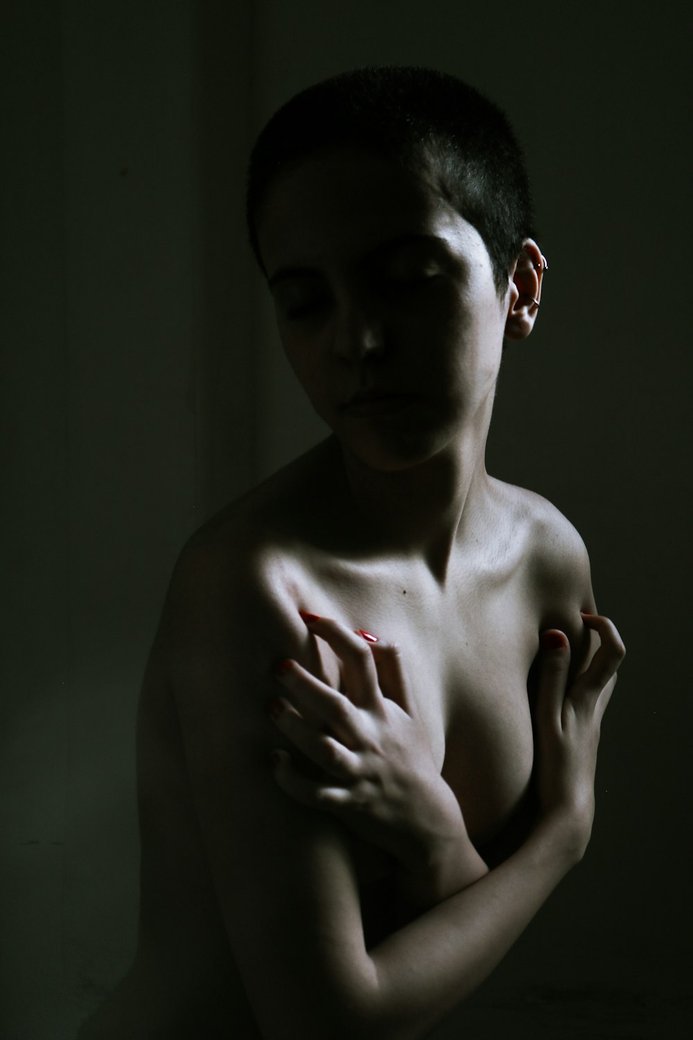 uma mulher nua com as mãos no peito