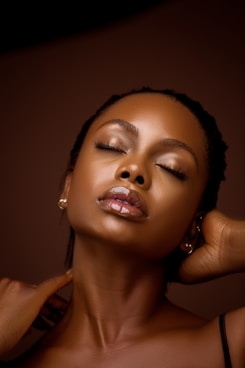 a woman with her eyes closed and her hands behind her head