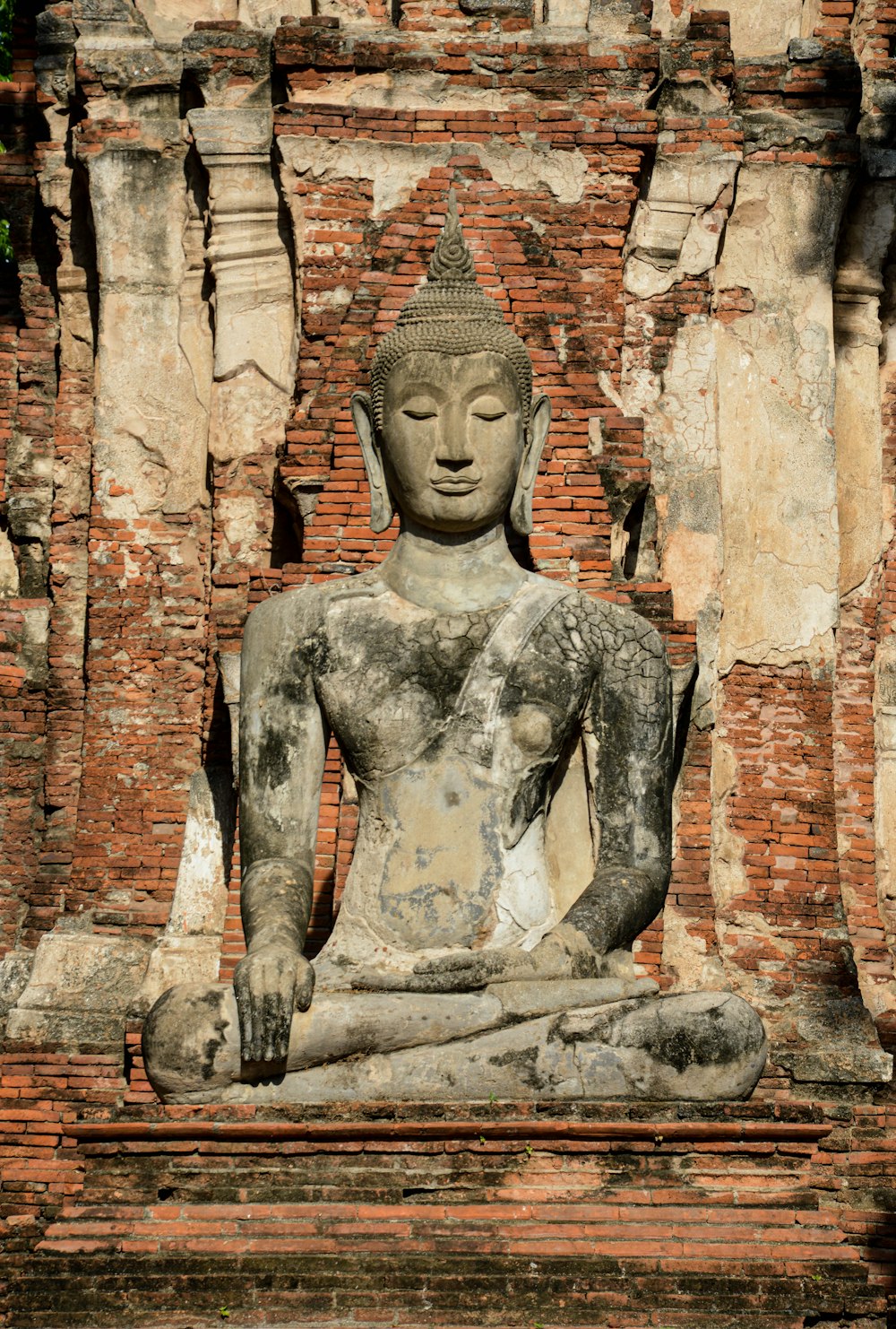 a statue of a person sitting in a meditation position