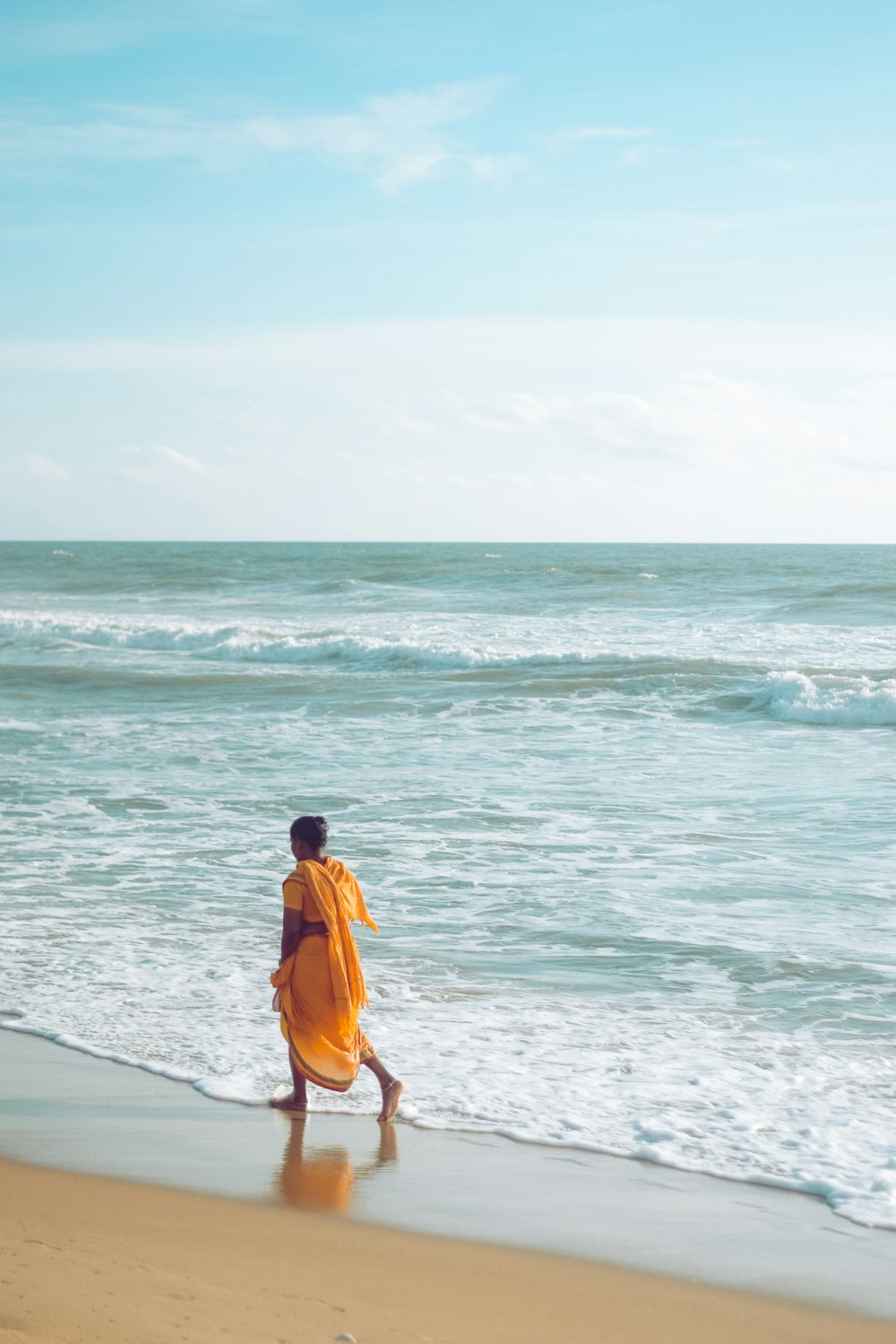 a person walking on the beach near the ocean