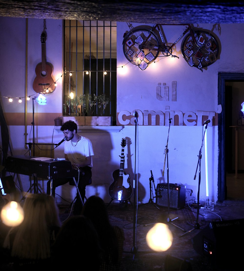 a man playing a guitar in front of a group of people