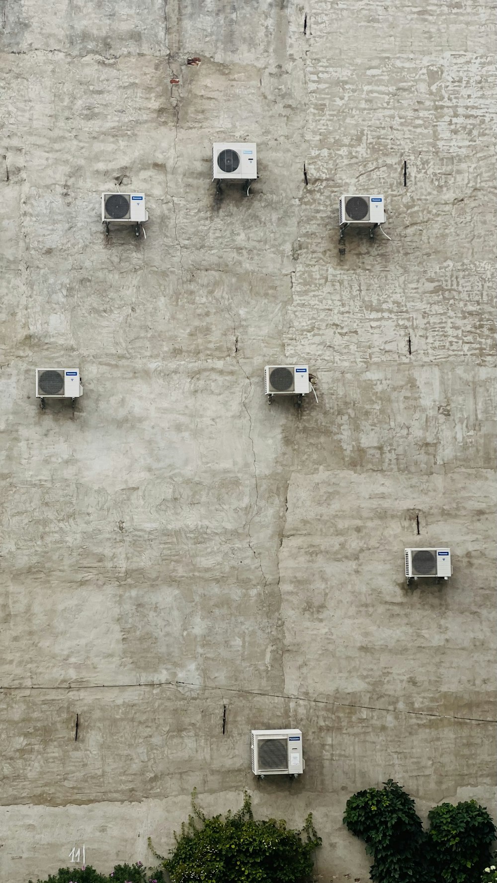 a wall with many air conditioners on it