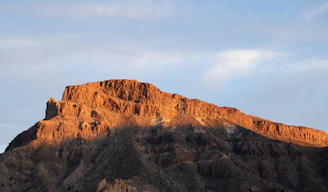 a very tall mountain with a sky in the background