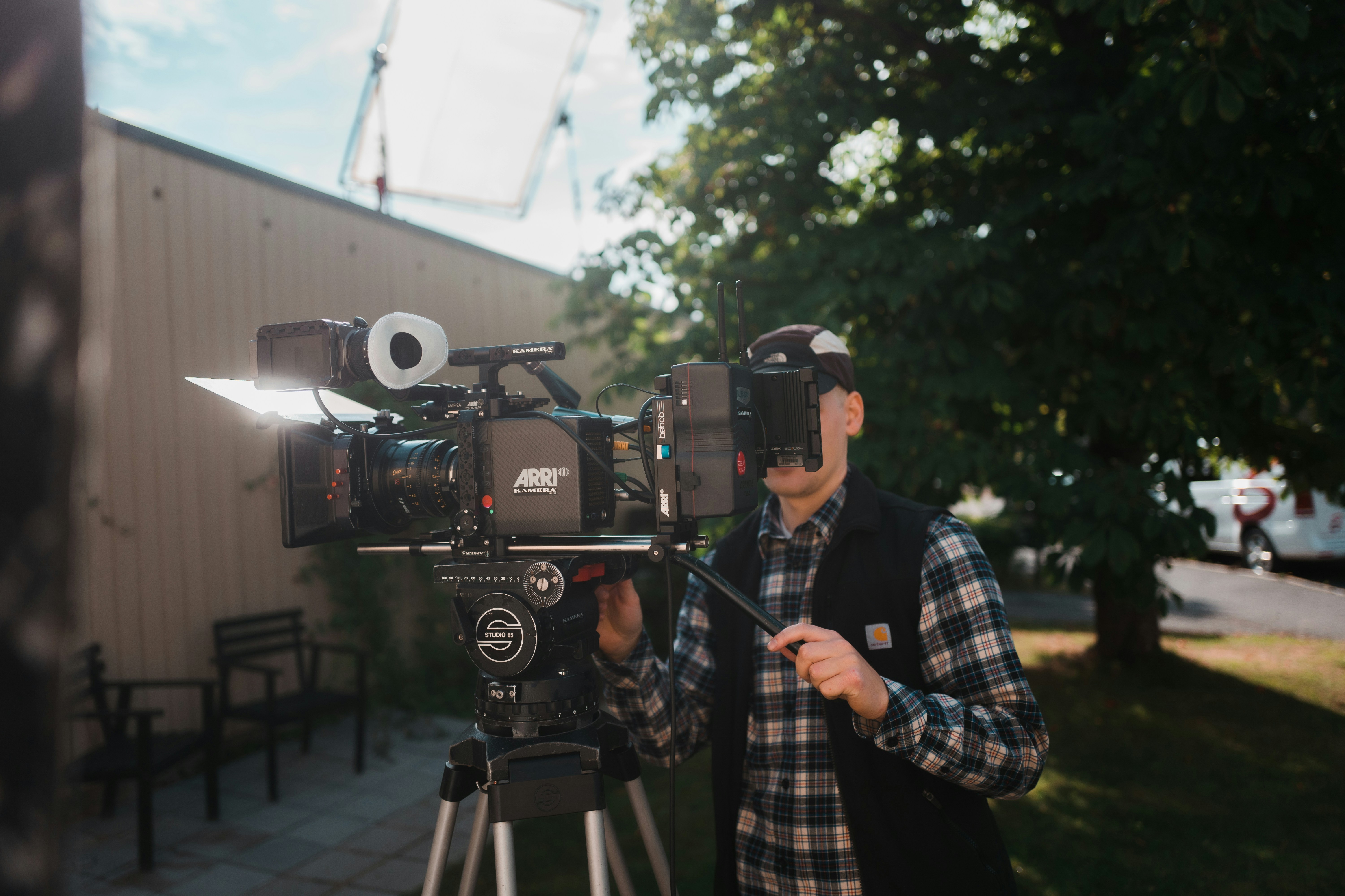Un uomo in piedi davanti a una telecamera su un treppiede