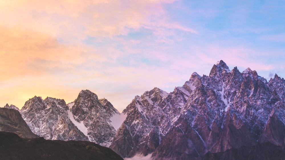 a mountain range with snow covered mountains in the background