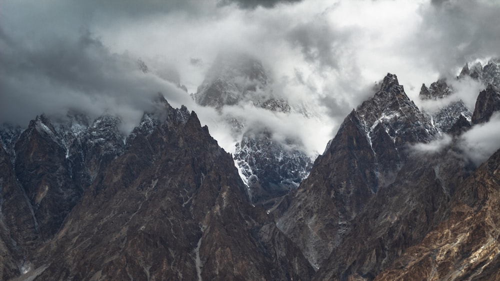 a mountain range covered in clouds and snow