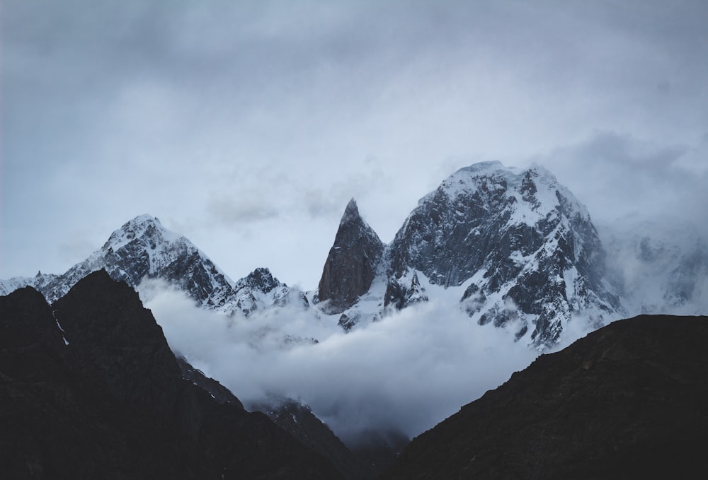 a mountain range covered in snow and clouds