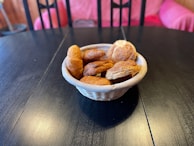 An assortment of fresh pastries and seasonal fruits neatly arranged in a wicker basket.