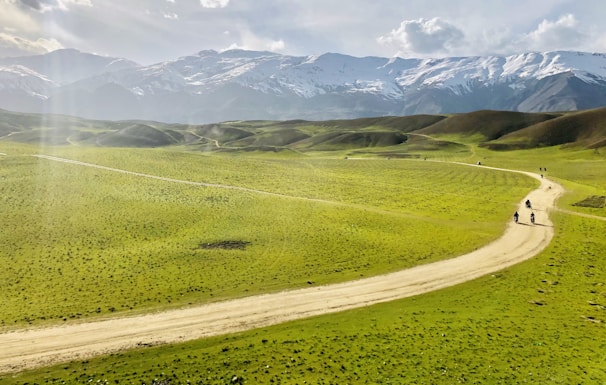 a couple of people walking down a dirt road