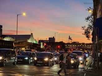 A bustling urban street scene at sunset with people wearing stylish modern clothing.