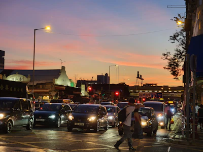 A vibrant city street at sunset bustling with people and colorful storefronts.