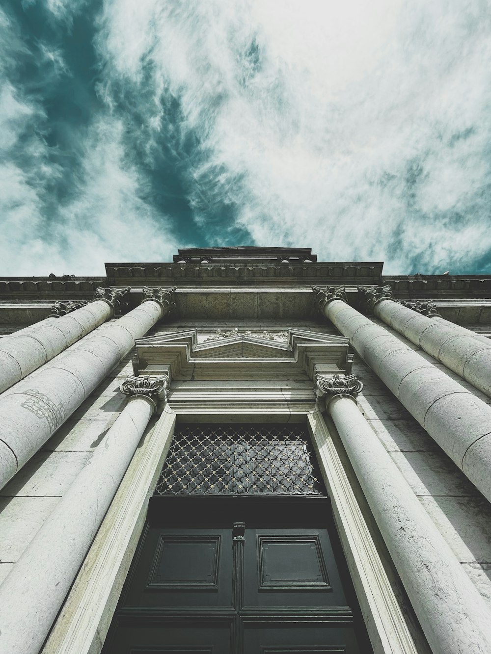 a tall building with columns and a sky background