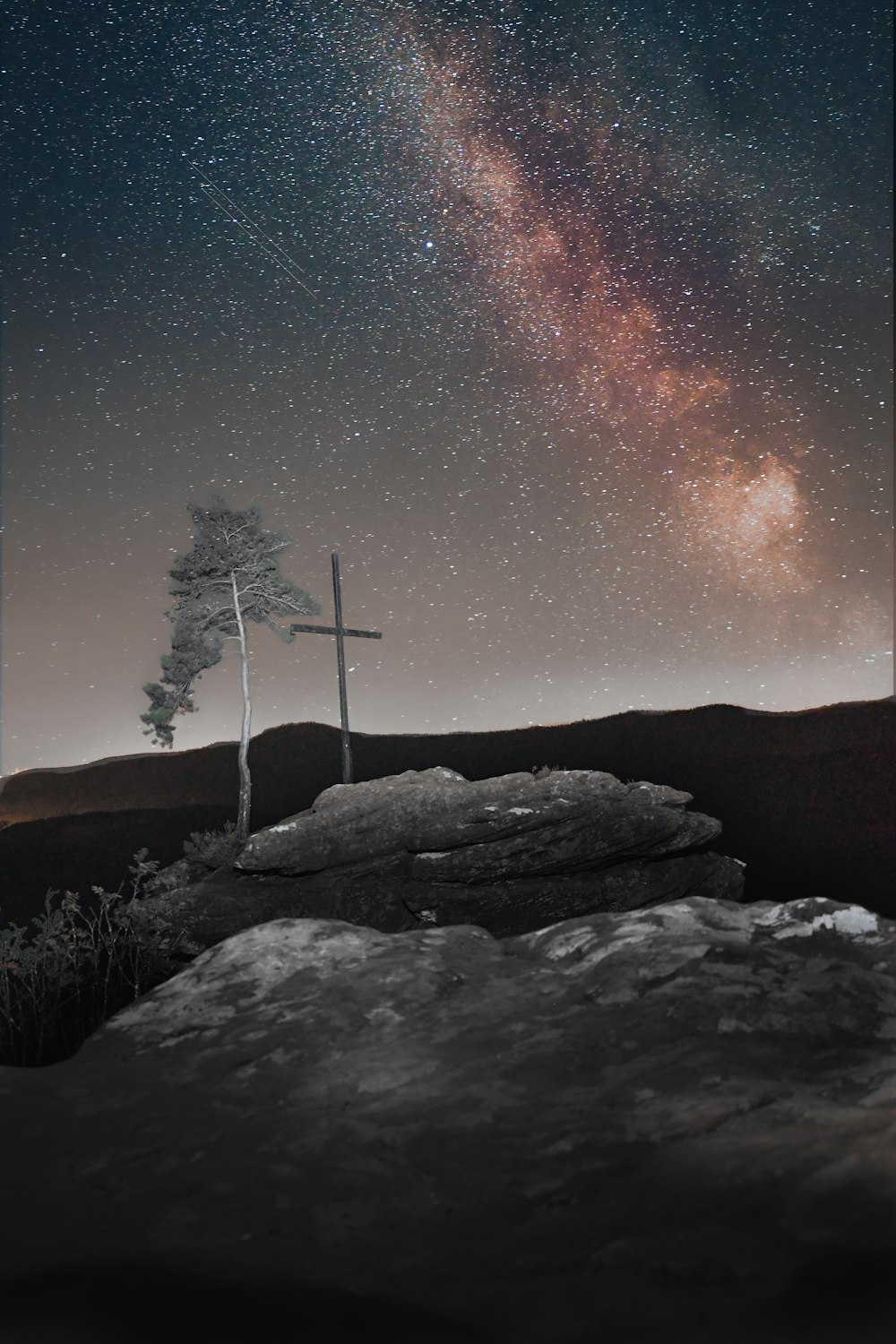 a cross on a hill under a night sky