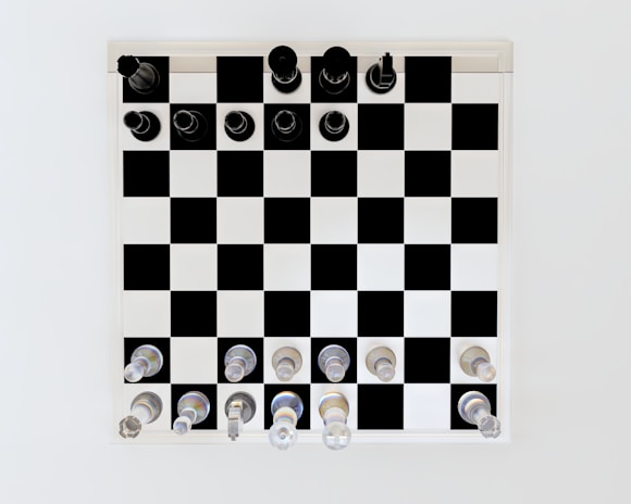A chess board is set with black and white chess pieces neatly arranged in their starting positions. The board has alternating black and white squares, and the pieces are placed precisely on each square. The white pieces are at the bottom and the black pieces are at the top.
