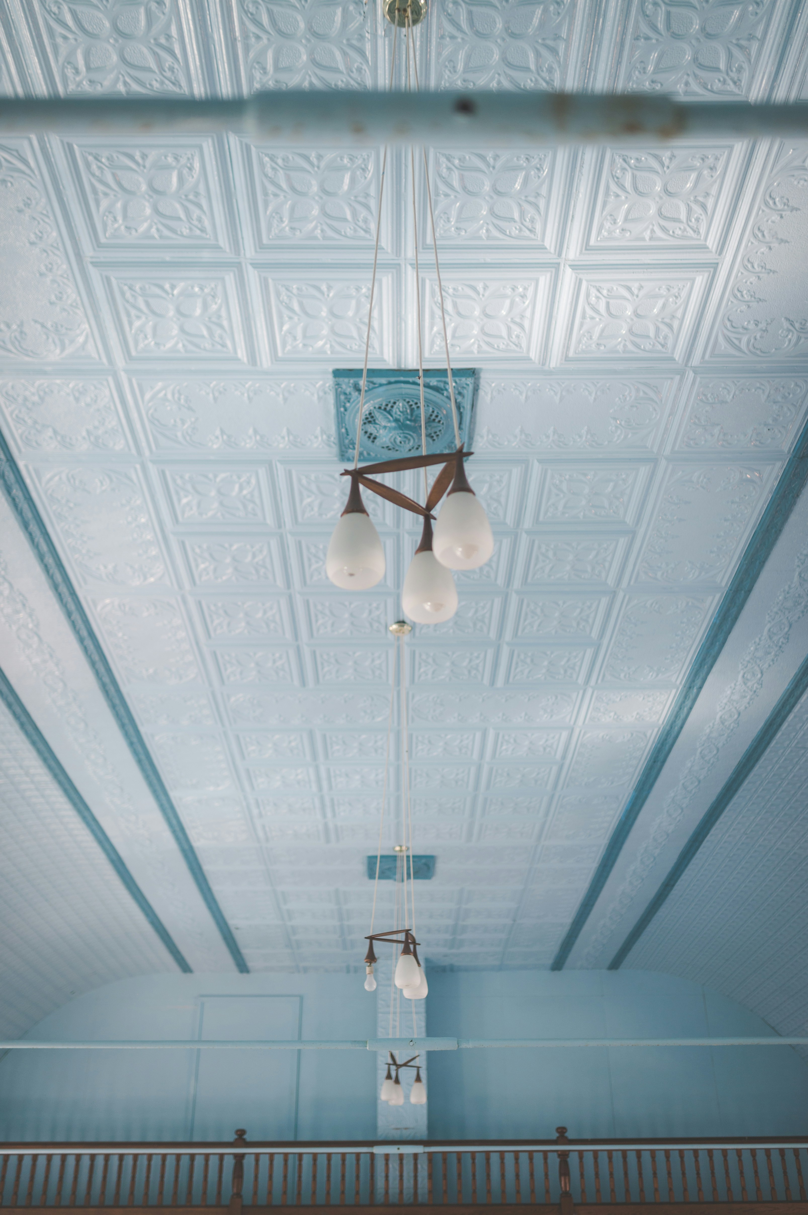 a room with a blue ceiling and a chandelier hanging from the ceiling