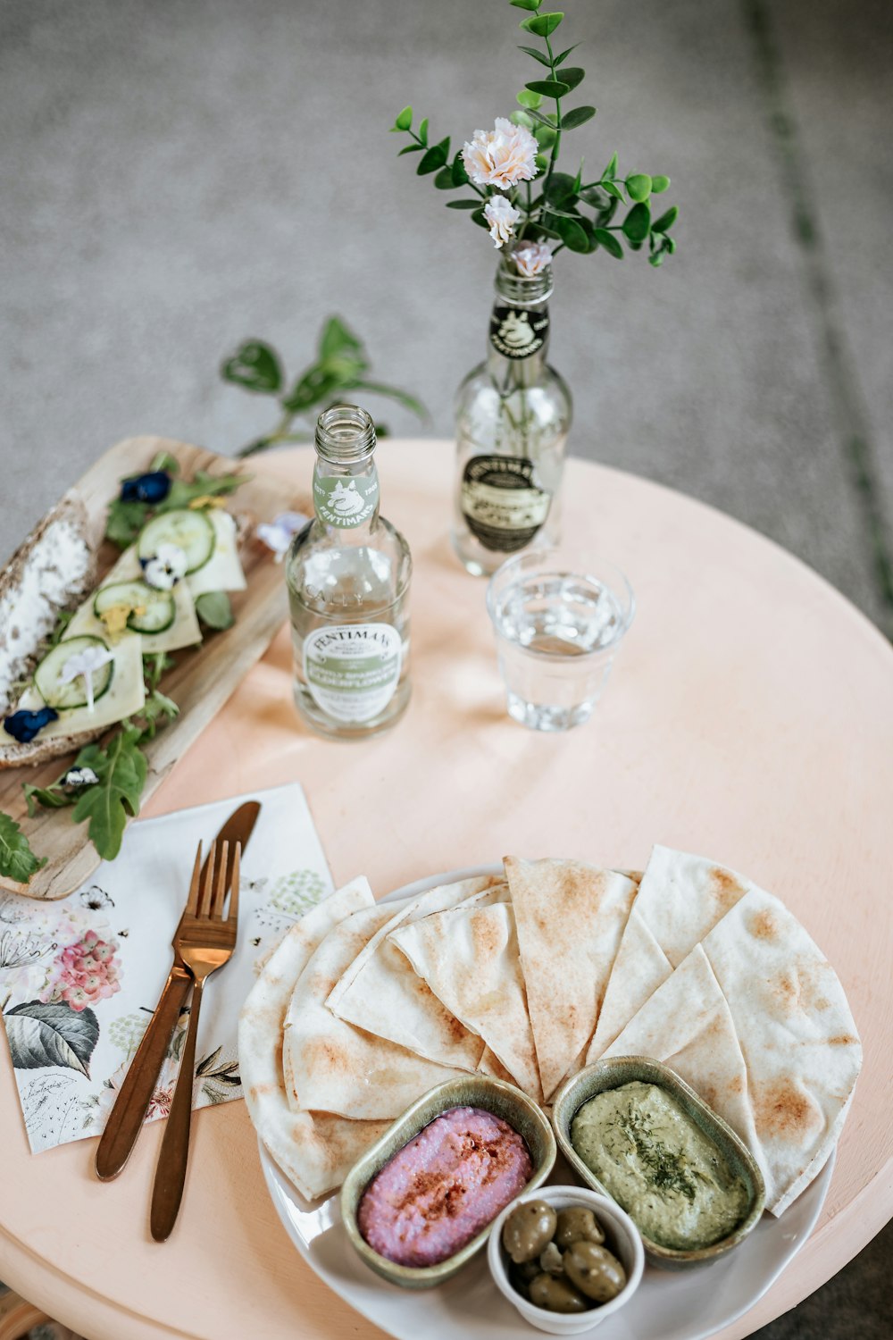 a table topped with a plate of food next to a vase of flowers