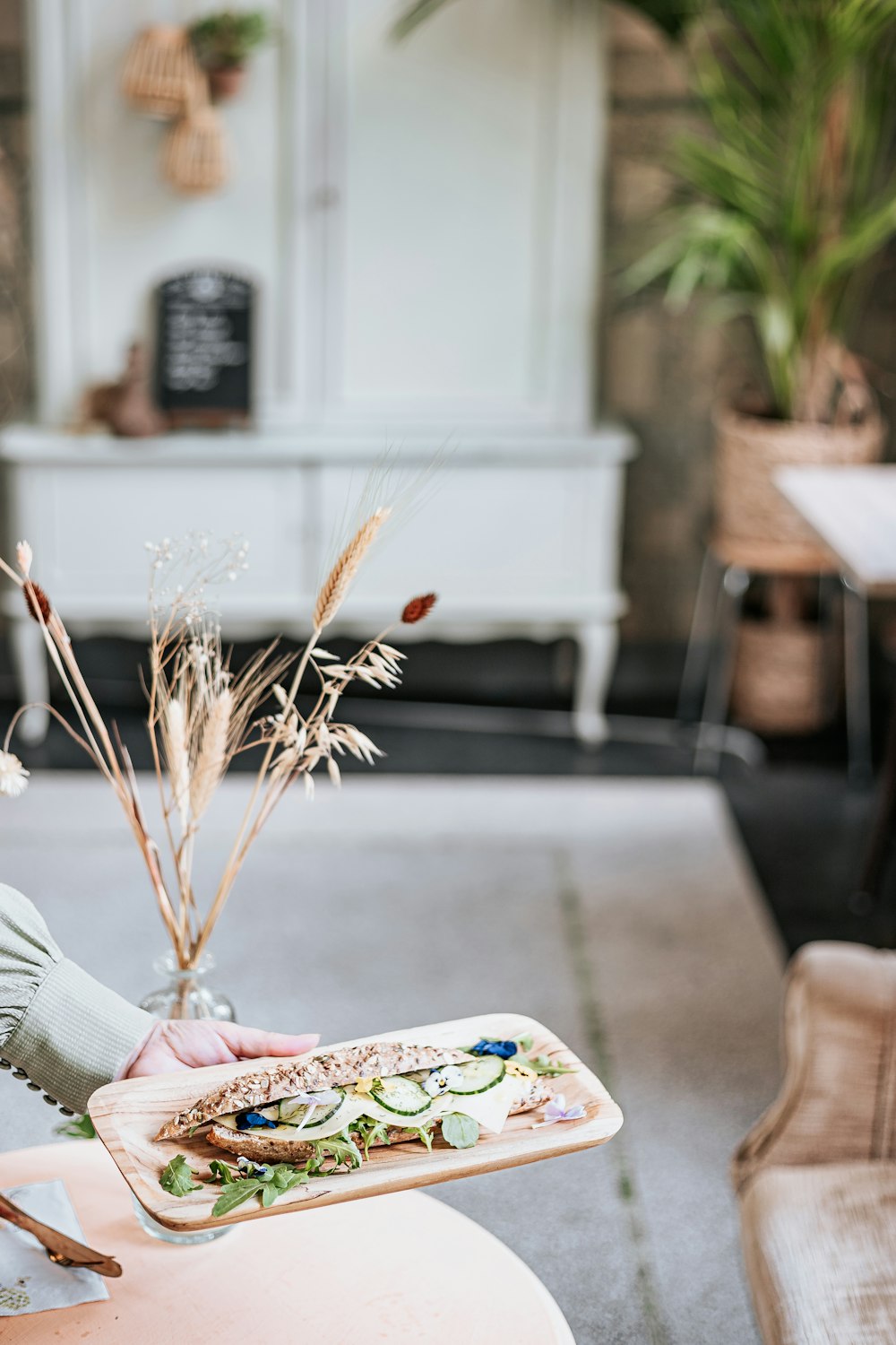 a person holding a tray of food on a table