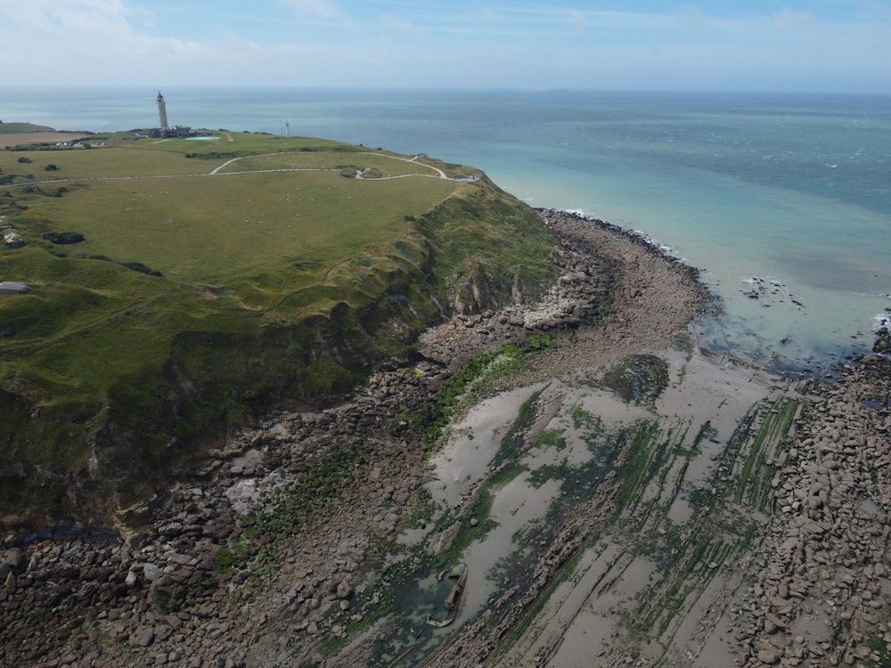 an aerial view of a beach with a lighthouse in the distance