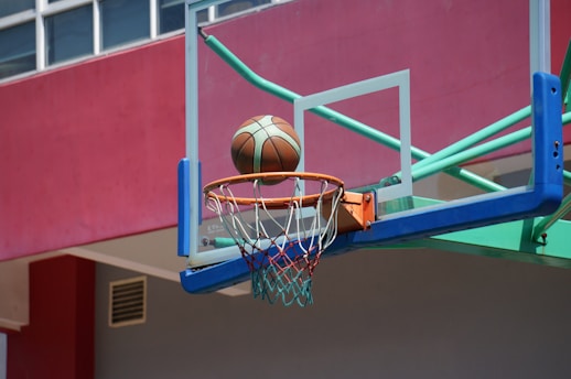 a basketball going through the hoop of a basketball court