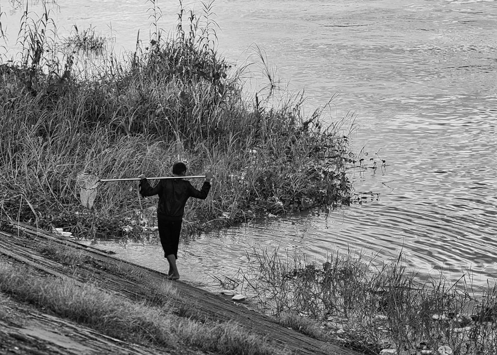 a person walking down a path next to a body of water