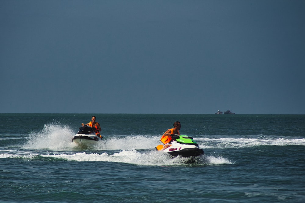 two people riding jet skis in the ocean
