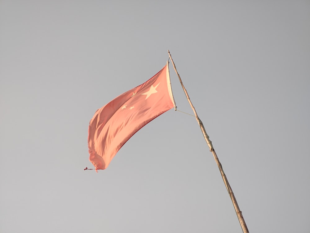 a flag flying in the wind on a pole