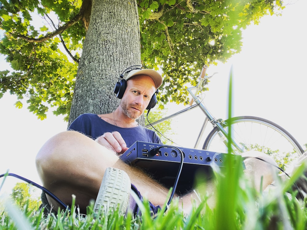 a man sitting in the grass with headphones on