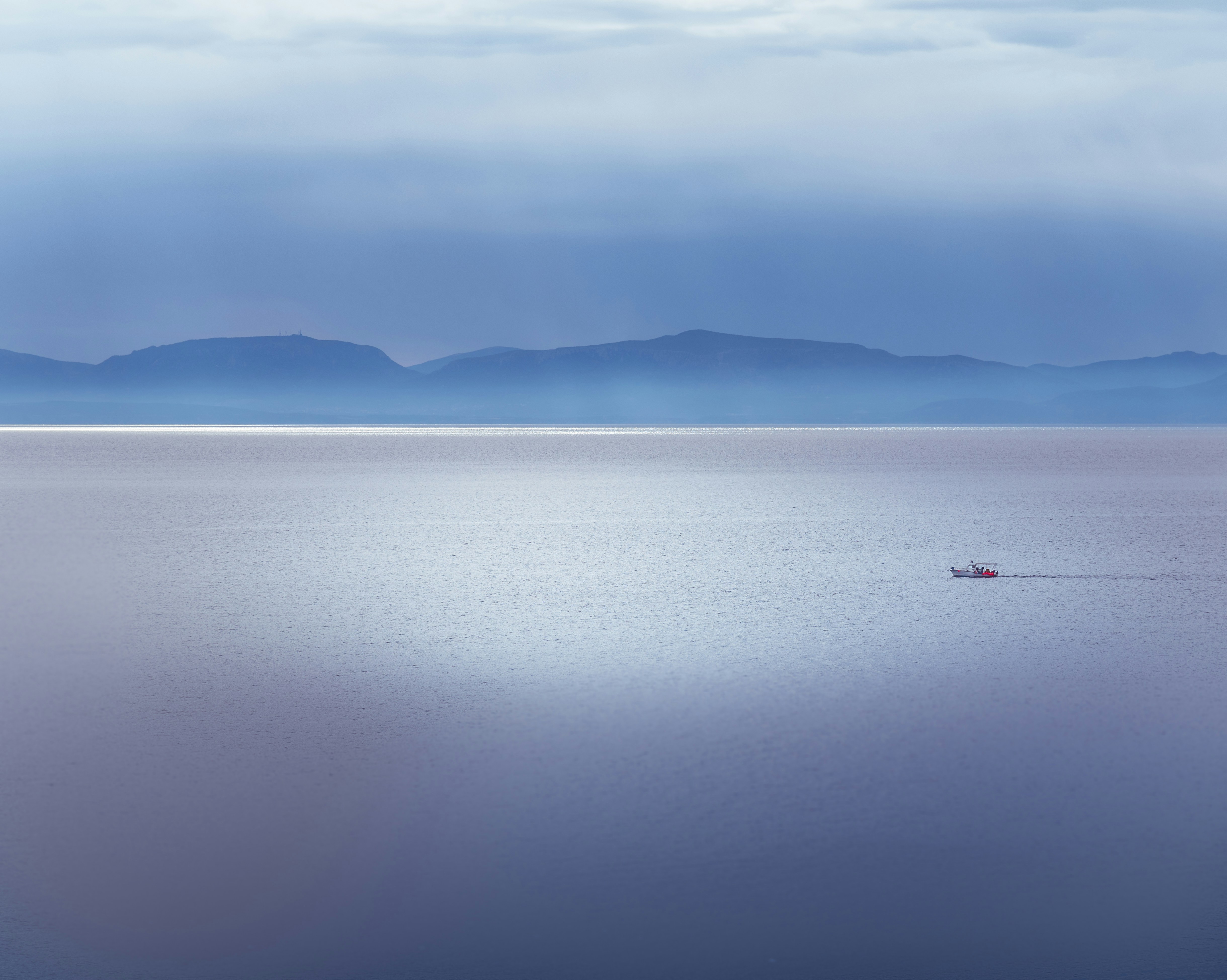 a lone boat in the middle of a large body of water