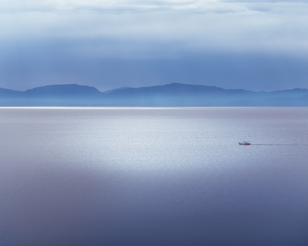 a lone boat in the middle of a large body of water