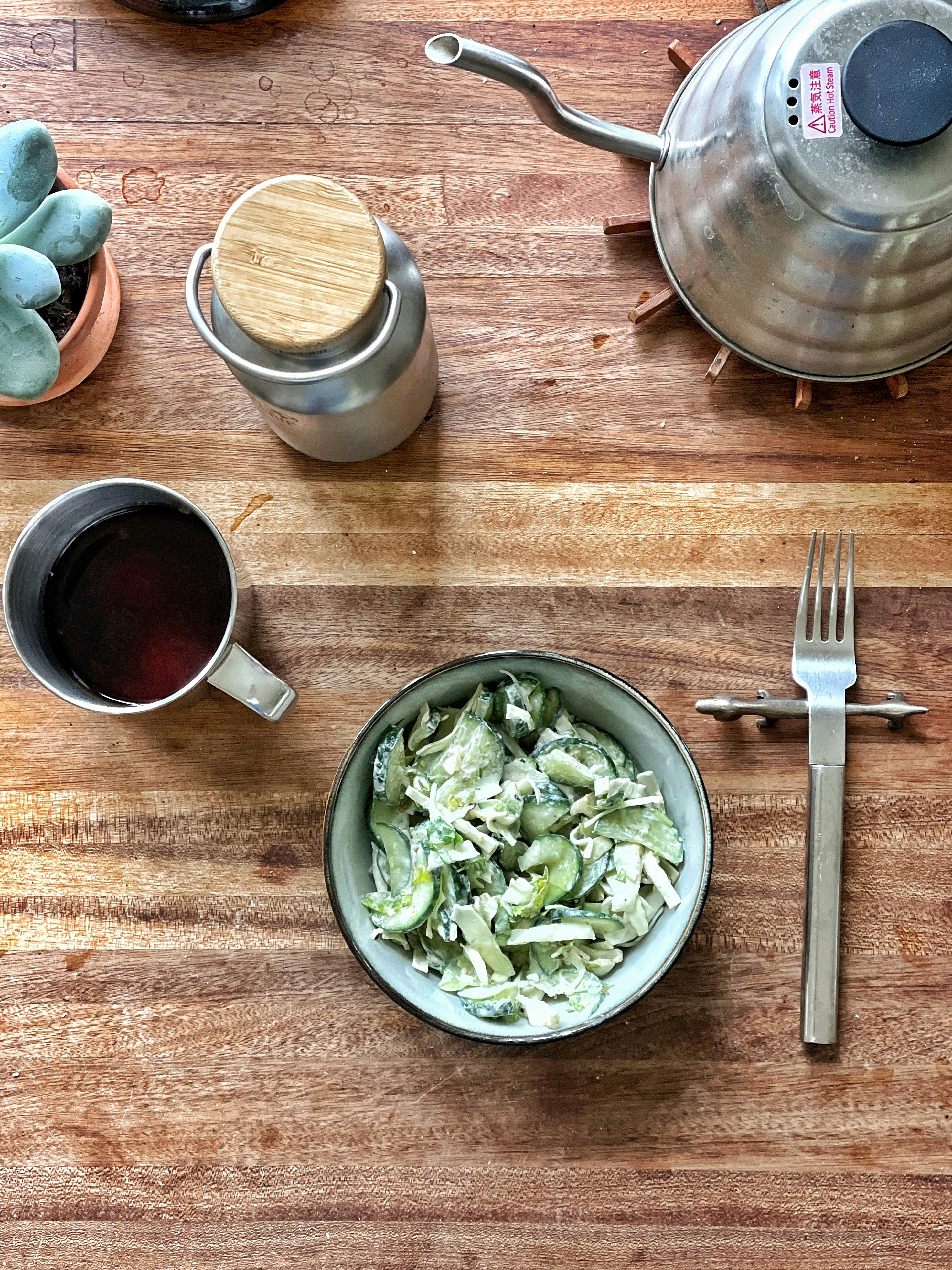a wooden table topped with a bowl of salad