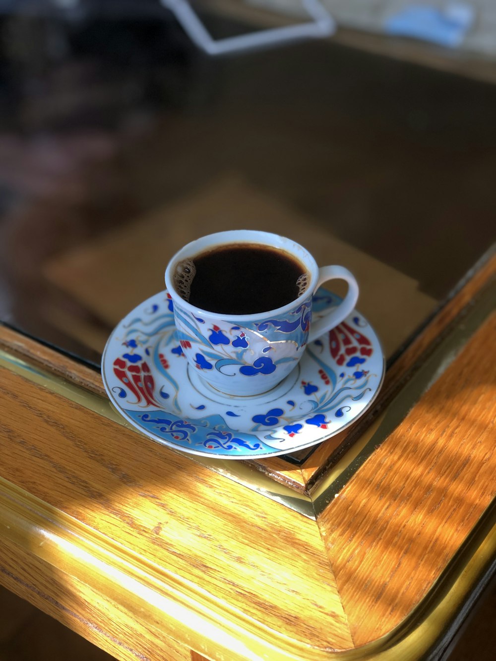 a cup of coffee sitting on top of a wooden table