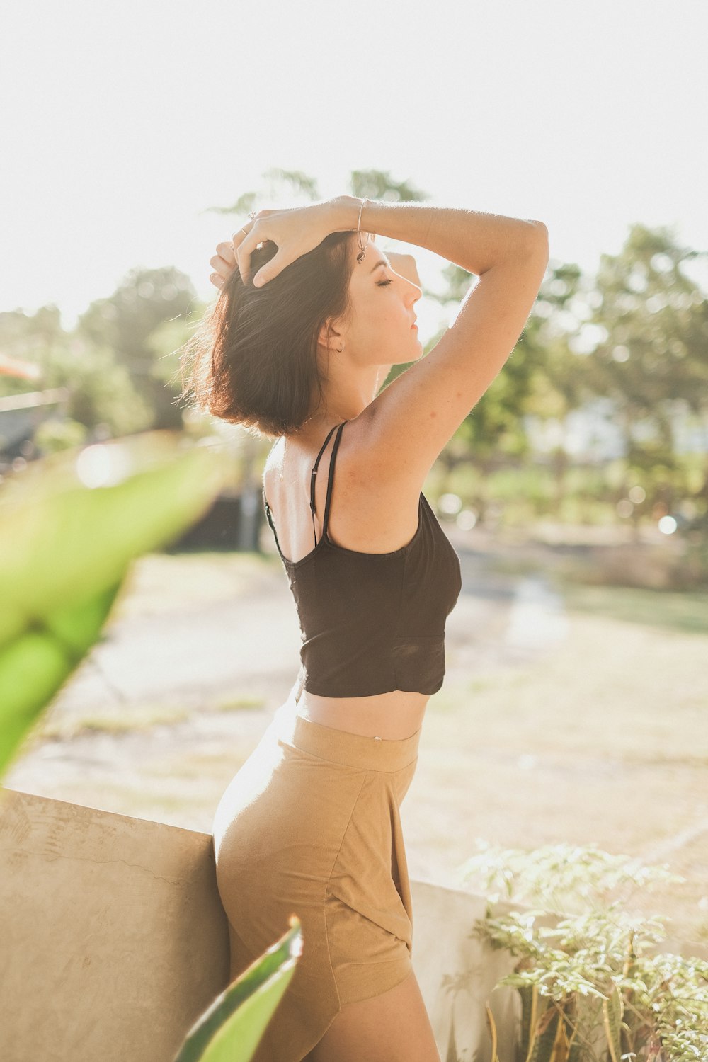 a woman leaning against a wall with her hand on her head