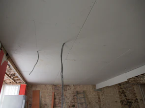 a room with a ladder and a brick wall