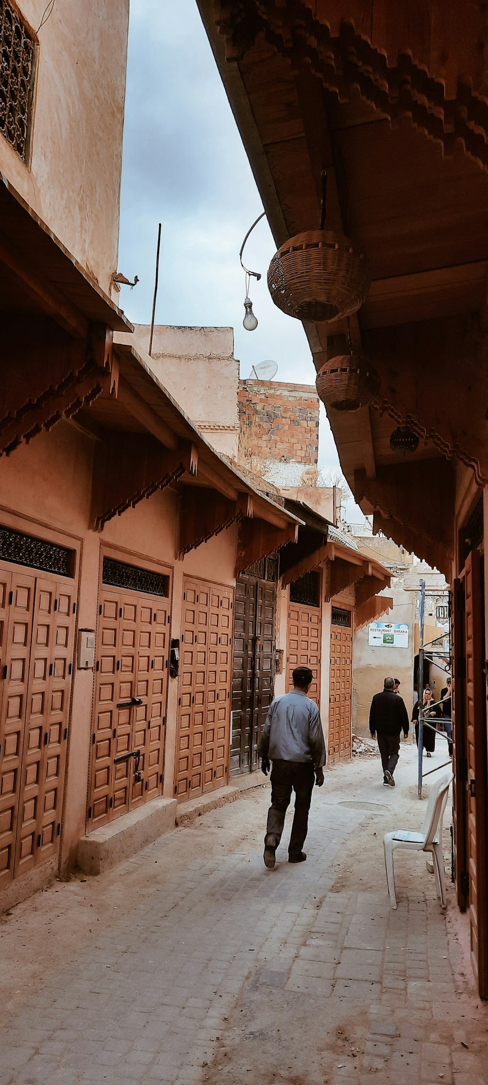 a man walking down a street next to tall buildings